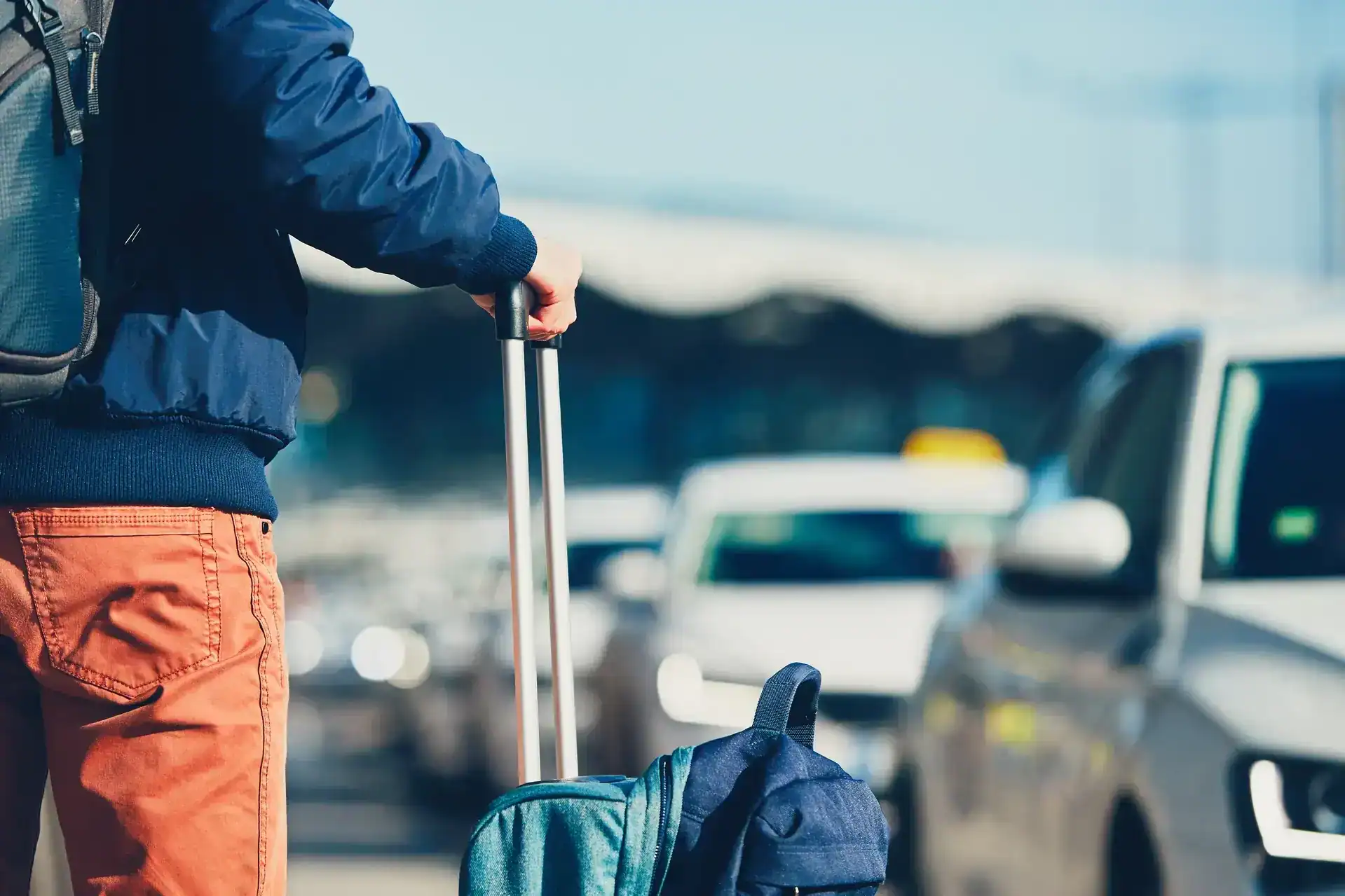 Traveler loading luggage into a curbside taxi at Jacksonville Airport in Duval County, Florida